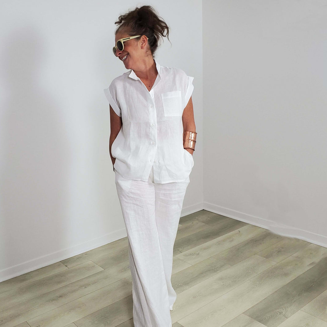 White linen blouse with cap sleeves and patch pocket. Made in Canada  Edit alt text